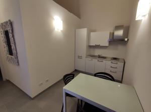 a small kitchen with a white table and chairs at Xeniahome in Castelvetrano Selinunte