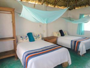 En eller flere senge i et værelse på Cabañas Calakmul