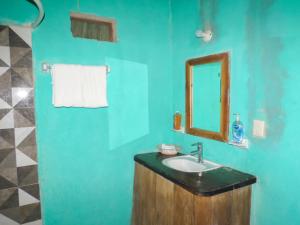 a blue bathroom with a sink and a mirror at Cabañas Calakmul in Conhuas