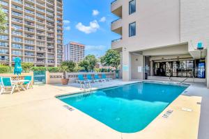 a swimming pool with chairs and a building at Penthouse Luxury Oceanfront Condo 3 Bedrooms 3 Bathrooms Ocean Dunes Tower 1 Unit 4155 in Myrtle Beach