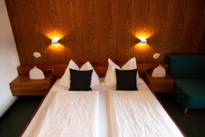 1 Schlafzimmer mit 2 Betten und einem grünen Stuhl in der Unterkunft Hotel Schönbrunn in Meran