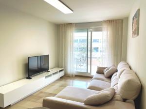 a living room with a couch and a flat screen tv at Golden Gardens Lux apartment Jávea in Jávea