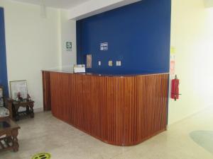 a lobby with a blue wall and a wooden counter at Hotel Villa Santa Ana in Quillabamba