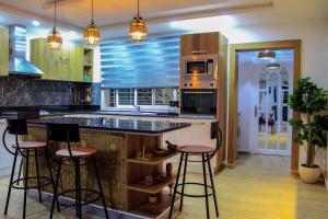 a kitchen with a island with bar stools at Villa Island Zembra in El Haouaria