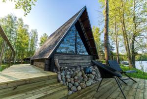 a log cabin with a deck and a fire pit at Laawu Kultaa in Kotka