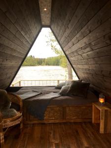 a bed in a cabin with a view of a river at Laawu Kultaa in Kotka