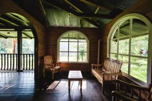 um quarto com duas cadeiras, uma mesa e janelas em Hotel en Finca Chijul, reserva natural privada em San Juan Chamelco