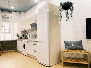 a kitchen with a white refrigerator in a room at Palacio Real Citymad in Madrid