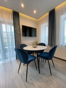 een eetkamer met een tafel en blauwe stoelen bij Luxury Apartments Keszthely in Keszthely