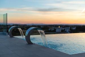 a swimming pool with water shooting into the sky at Salina Hotel in Taranto