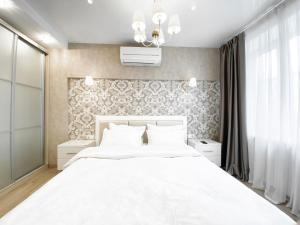 a bedroom with a large white bed and a wall at 2-bedroom apartment Most City Area, Ekaterynoslav square in Dnipro