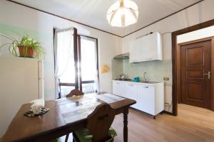 eine Küche mit einem Holztisch und einem Kühlschrank in der Unterkunft CASA MARGHERITA in Baveno