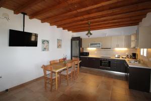 a kitchen with a table and chairs in a room at Blue Xenia - Villa 2 in Chrissi Akti