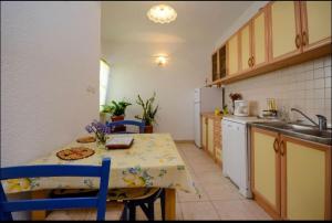 a kitchen with a table and a sink and a table and chairs at Milojka in Senj