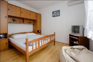 a bedroom with a wooden bed and a tv at Milojka in Senj
