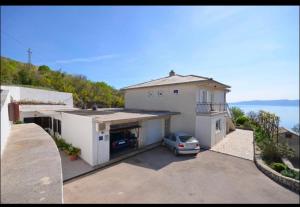 a house with a car parked in a parking lot at Milojka in Senj