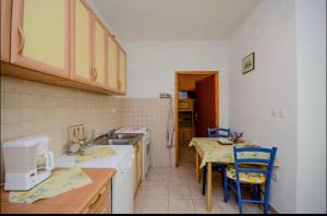 a kitchen with a sink and a table with chairs at Milojka in Senj