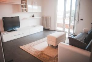 a living room with a tv and a couch and a chair at NOVA DOMUS FLAT Free Private Parking in Siena