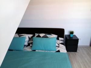 a bedroom with a bed with blue and white pillows at Pokoje Gościnne Izabela in Władysławowo