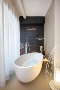 a bath tub in a bathroom with a wall with fishes at Life Class Apartment in Riomaggiore