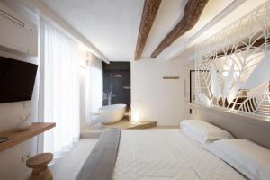 a bedroom with a large bed and a bath tub at Life Class Apartment in Riomaggiore