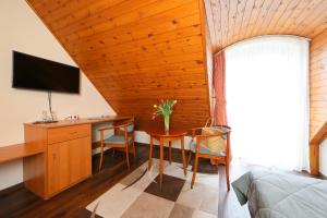 Dormitorio con escritorio, cama y TV en Balazs Villa, en Balatonfüred