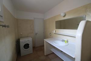 a bathroom with a sink and a washing machine at Blue Xenia - Villa 4 in Chrissi Akti