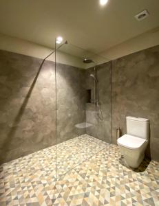 a bathroom with a toilet and a glass shower at Casa Elvira in Torroella de Montgrí