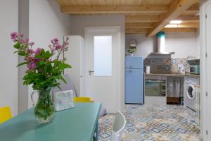 uma cozinha com uma mesa azul com flores num vaso em Casa Doade, en A Ribeira Sacra em Doade