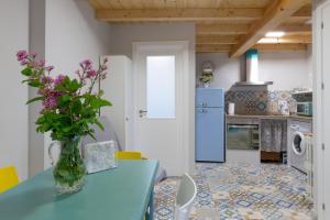 a kitchen with a blue table with flowers in a vase at Casa Doade, en A Ribeira Sacra in Doade
