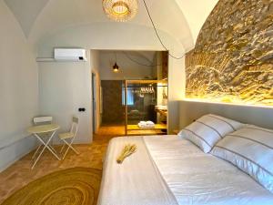 Un dormitorio con una gran cama blanca y una mesa en Casa Elvira en Torroella de Montgrí