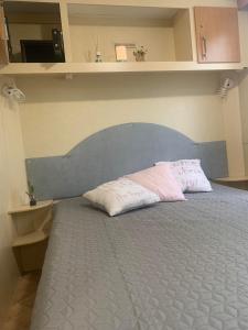 łóżko z 2 poduszkami w pokoju w obiekcie Hama Mobilehome Grado w Grado