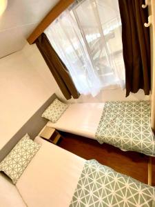 mały pokój z 2 łóżkami i oknem w obiekcie Hama Mobilehome Grado w Grado