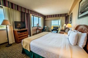 a hotel room with a large bed and a television at Emerald Beach Hotel Corpus Christi in Corpus Christi