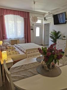 エゲルにあるFoglal-lak Apartmanのベッドルーム1室(ベッド1台、花のテーブル付)