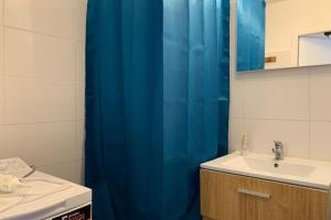a bathroom with a blue shower curtain and a sink at The ingenious blue #BS in Grenoble