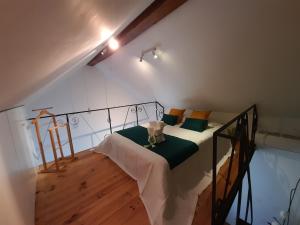 a bedroom with a bed with green and yellow pillows at Casas do Arrabalde in Amarante