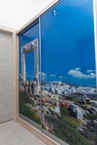 a window with a view of the ruins ofhens at AZUR in Naxos Chora