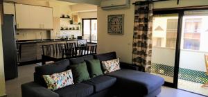 a living room with a couch and a kitchen at Large Apartment near the beach and Lisbon in Costa da Caparica