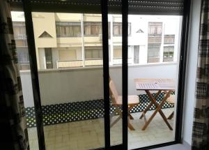 a view of a balcony with a table and a chair at Large Apartment near the beach and Lisbon in Costa da Caparica