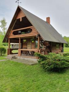 a large wooden cabin with a pitched roof at Vēl tuvāk dabai in Kundzinisķi