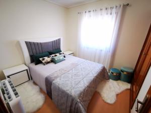 een slaapkamer met een groot bed en een raam bij Vagueira casa férias in Aveiro