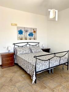 um quarto com uma cama e duas pinturas na parede em Villa Lo Scoglio em Ascea