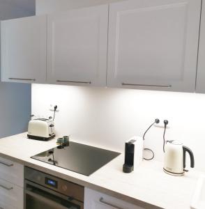 a kitchen with white cabinets and a sink at Hillside Apartment with AC & heating in Grande Maison in Budapest