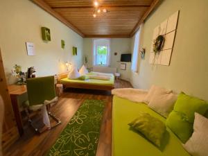 Gasthof Wölger في أدمونت: غرفة معيشة مع أريكة خضراء وطاولة