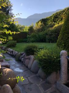 a garden with a stone wall and a path at Rayon de Soleil in Saint Vincent