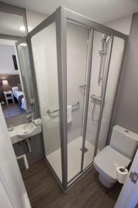 Un baño con ducha, inodoro y lavabo. en Pensión San Martin, en San Sebastián