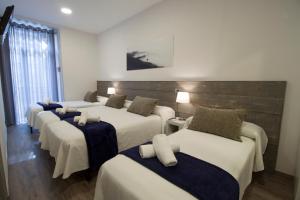 a group of four beds in a room at Pensión San Martin in San Sebastián