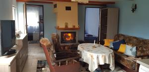 a living room with a table and a fireplace at Domek za starą stodołą in Wydminy