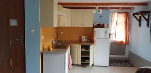 a kitchen with a sink and a refrigerator at Domek za starą stodołą in Wydminy